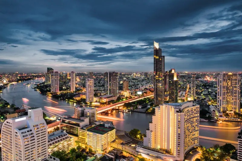 Bangkok's riverside financial district at dusk, where foreigners living in Thailand receive offshore transfers.
