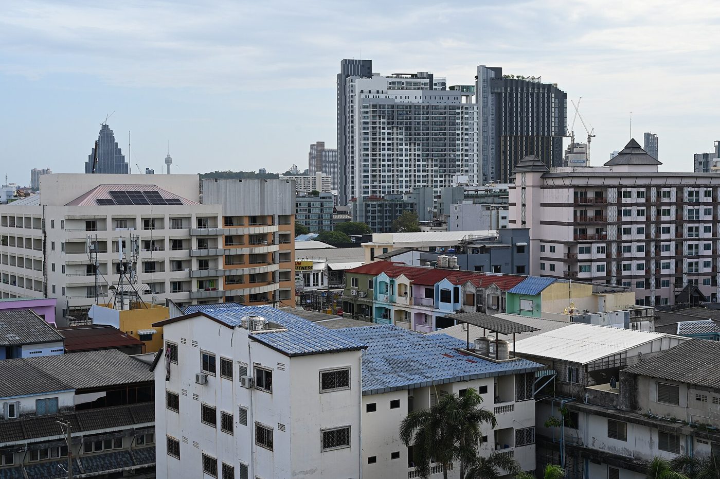 Pattaya skyline with low-rise apartment blocks in the foreground and modern high-rise condos behind, showing the mixed housing stock affected by the Thailand Hotel Act rewrite for people living in Thailand.