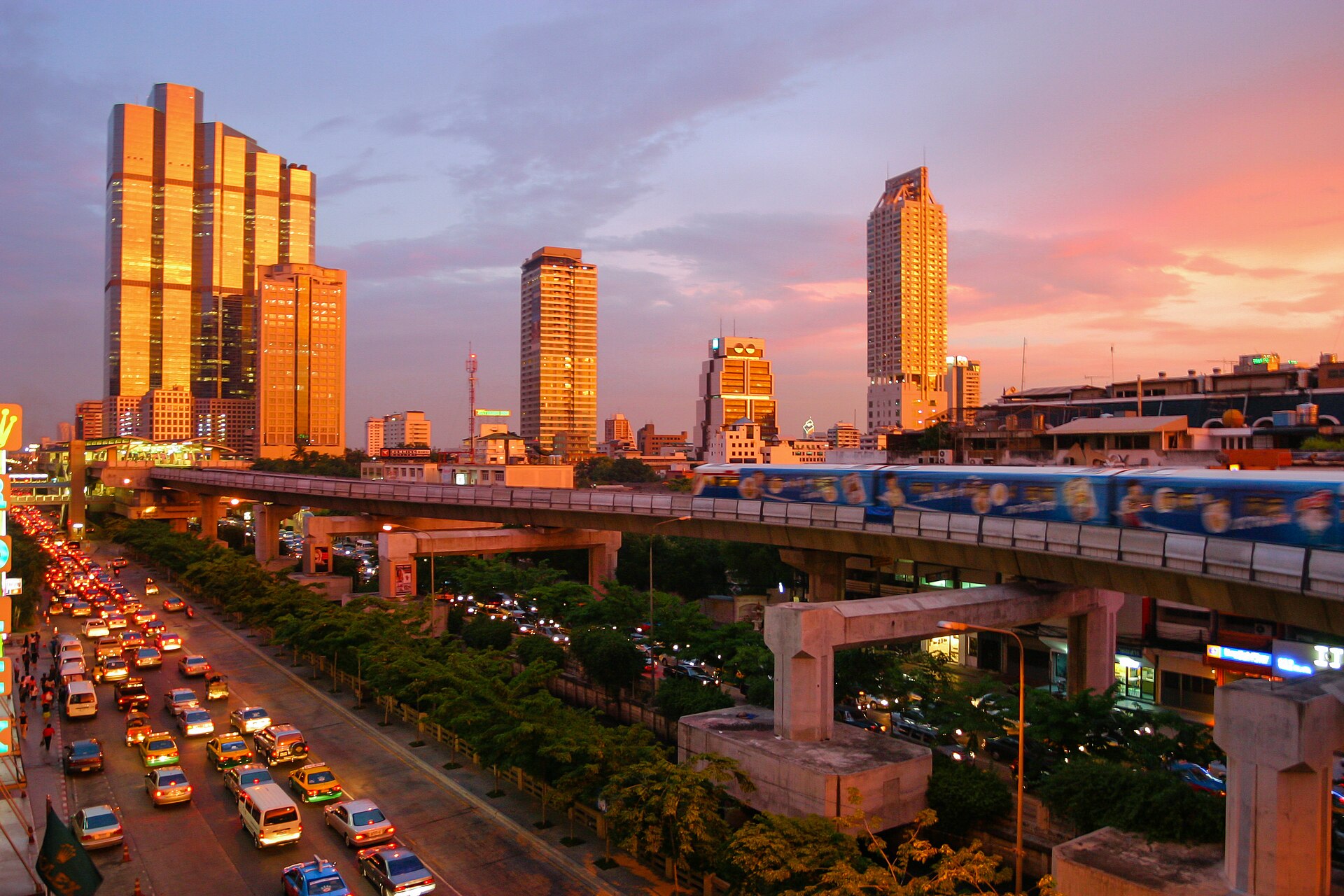 Bangkok skytrain and city skyline at sunset, a typical Bangkok expat view where the cost of living in Thailand depends on the baht exchange rate.