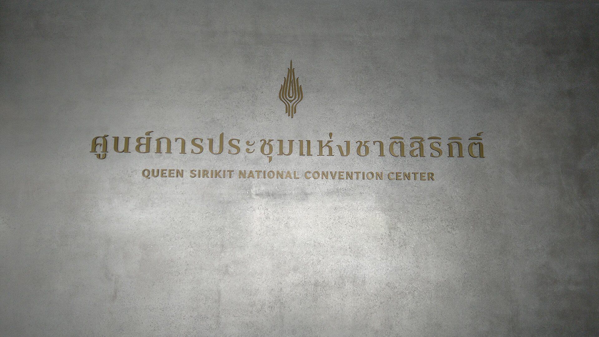 Gold Thai and English lettering reading Queen Sirikit National Convention Center, the Bangkok venue hosting the October 2026 IMF-World Bank meetings and affected by Thai visa rules for visitors.