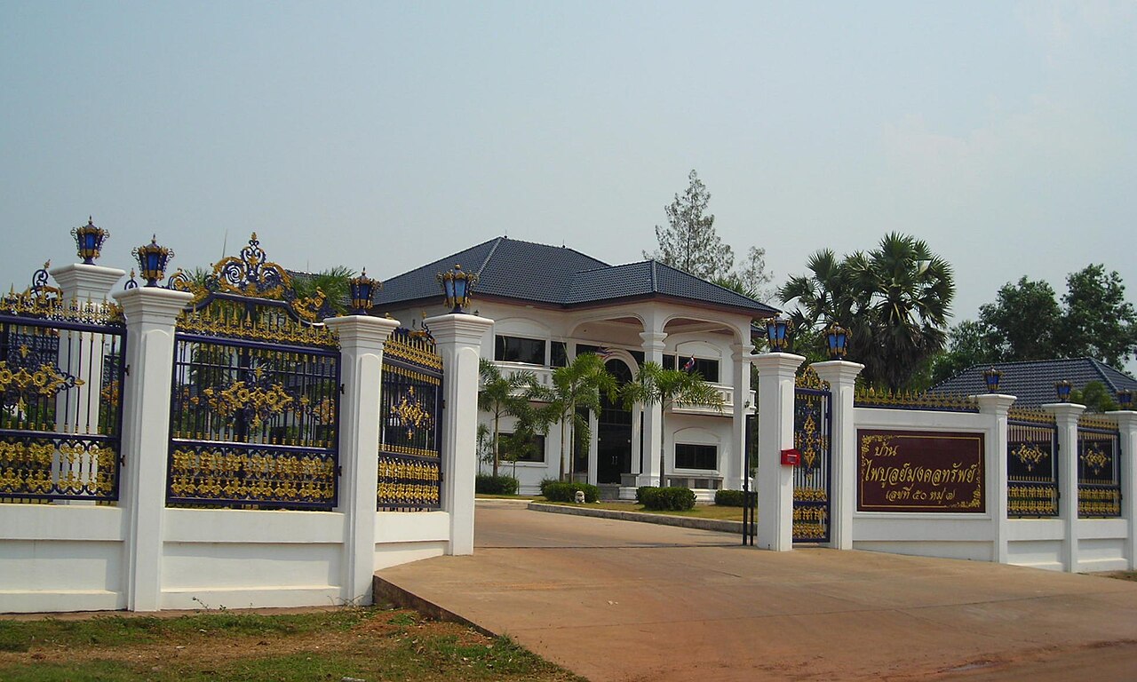Gated two-storey Thai villa with ornate fence, an example of the detached houses foreigners consider when moving to Thailand and why legal land ownership structure matters.