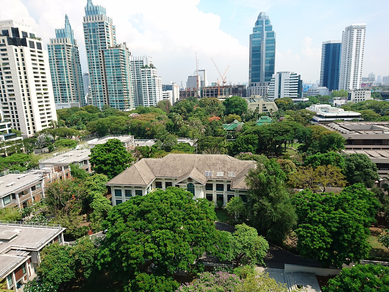 View over green treetops to the British Embassy compound and Bangkok high-rises, Thailand, where British expats living in Thailand turn for consular help in an emergency