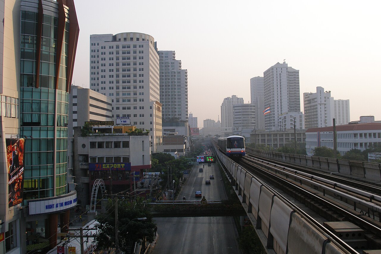Bangkok condo towers beside the BTS Skytrain line at sunset in Thailand, showing why rail access matters for Bangkok expat renters and buyers moving to Thailand