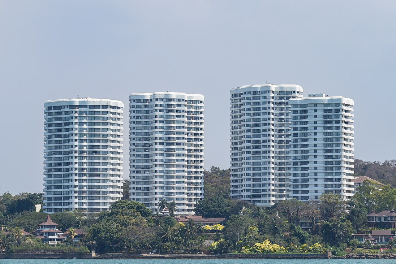 White condominium towers on the Pattaya coast in Thailand, the kind of foreign-owned condo stock that stays legal under the 49 percent quota while the nominee land crackdown targets land held through Thai fronts, relevant to anyone moving to Thailand